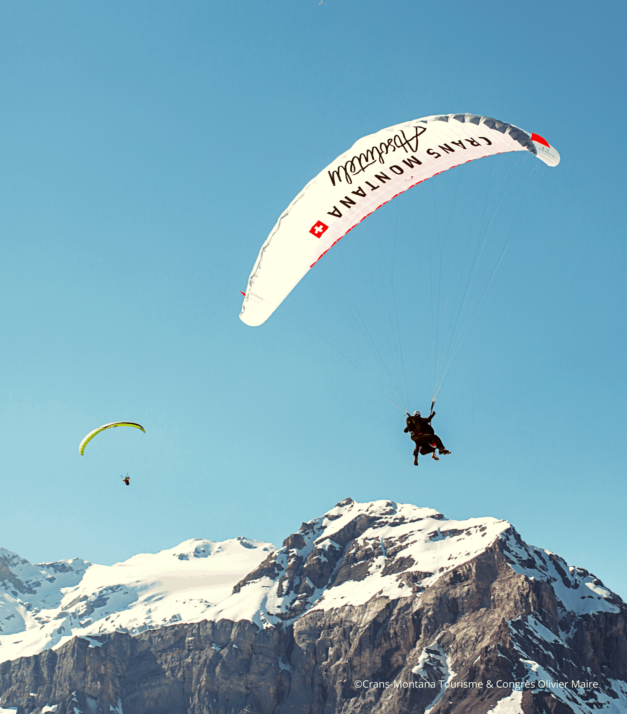 paraglider flying over the Crans Montana Region