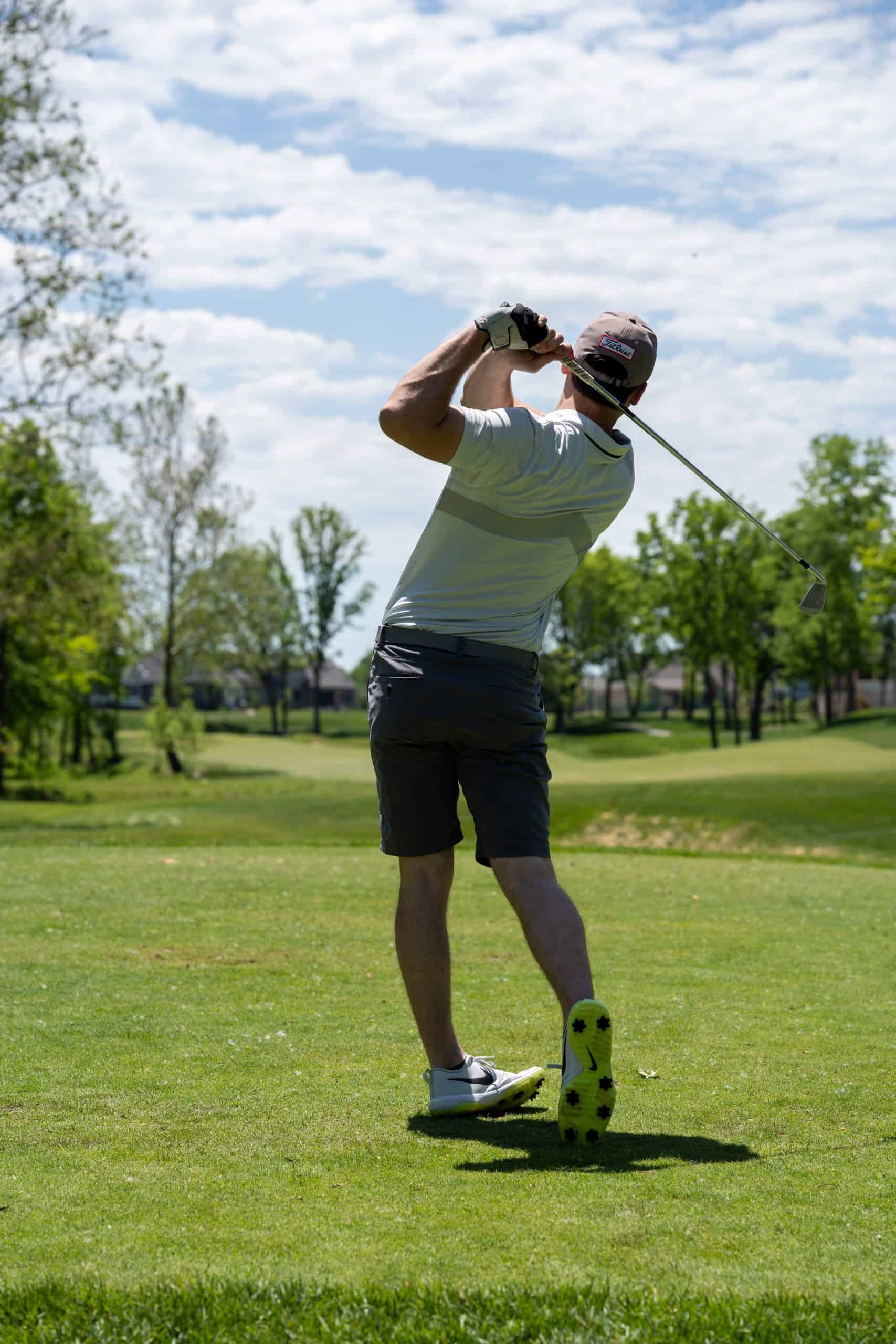 a man playing golf under the sun